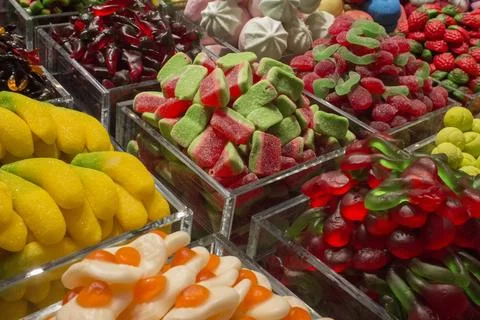 Many different kinds of candies in boxes stand on the shelves Foto stock