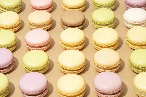 The many different macarons are arranged in rows on the table Stock Photos