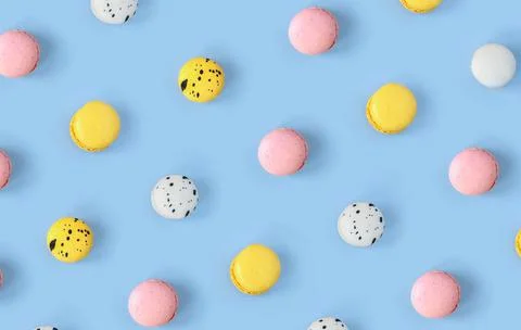 Many different macaroons pattern on blue background. Pink, white and yellow Stock Photos