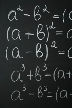 Many different math formulas written on chalkboard, closeup Stock Photos
