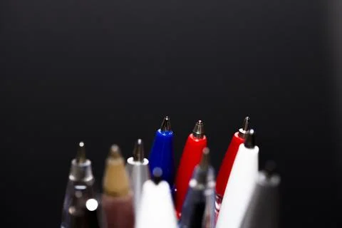 Many different multi-colored pens isolated on black background Stock Photos