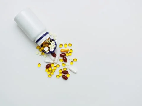 Many different multi-colored vitamins and minerals scattered from a plastic Stock Photos