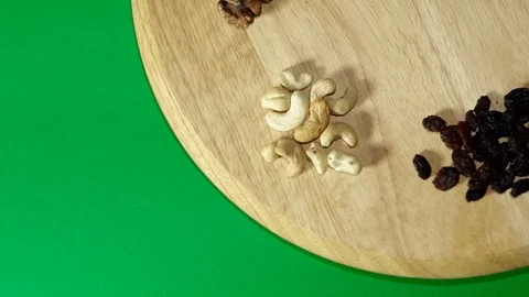 Many different nuts rotate 360 degrees on the Board and green background Stockbeeldmateriaal 119580399