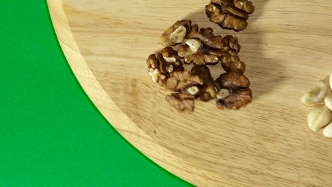Many different nuts rotate 360 degrees on the Board and green background Stock Footage 119842484