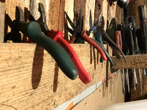 Many different old tools hanging on a wooden wall Stock-Fotos