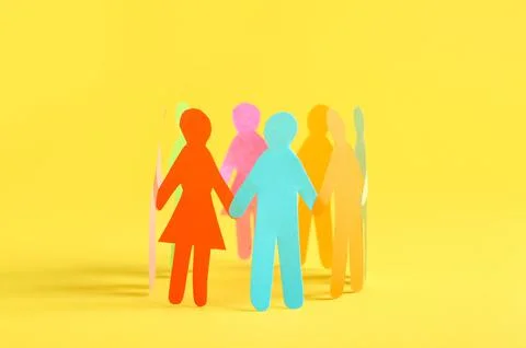 Many different paper human figures standing in circle on yellow background. D Stock Photos
