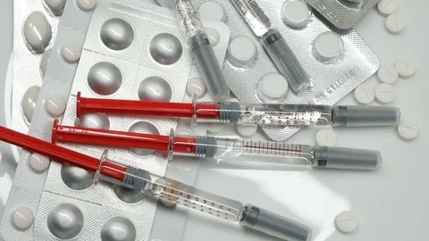 Many different pills tablet blister packages and unused syringes rotating Stock Footage 83692424