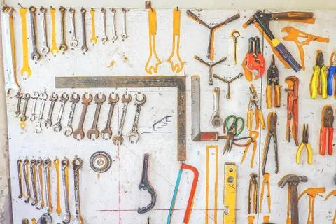 Many different rusty old tools hanging on a wall Stock Photos