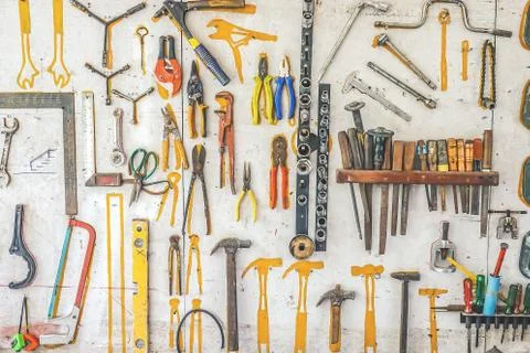 Many different rusty old tools hanging on a wall Stock Photos