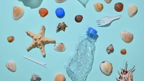 Many different seashells and plastic trash on a blue background. Stock Footage 223706015