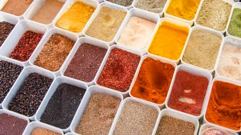 Many different spicy fragrant multi-colored condiments in containers Stock Photos