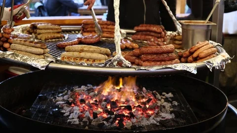 Many different types of grilled sausages are fried in a large pan Stock Footage 124114766