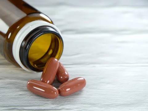 Many different types of medicines poured out of brown bottles on a white-gr.. Stock Photos