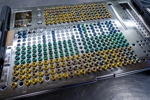 Many different types of titanium surgical screws are sorted into a tray accor Stock Photos