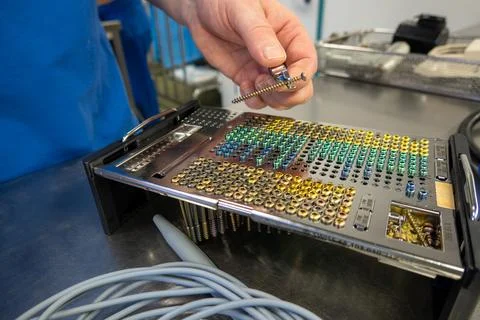 Many different types of titanium surgical screws are sorted into a tray accor Stock Photos