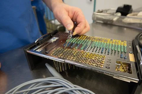 Many different types of titanium surgical screws are sorted into a tray accor Stock Photos