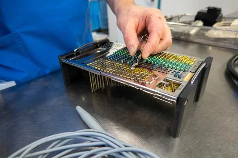 Many different types of titanium surgical screws are sorted into a tray accor Stock Photos