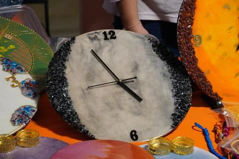 Many different wall clock displayed for sale. Round frame orange and gray col Stock Photos