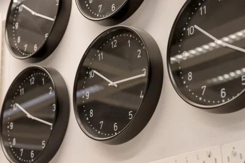 Many different wall clock on the wall .Set of clockfaces isolated. Concept of Stock Photos
