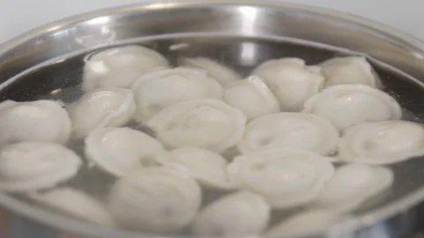 Many dumplings in boiling and steaming pot water. Cooking dumplings. Famous Stock Footage 128298124