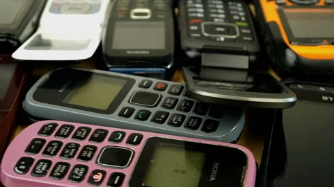 Many dusty push-button old and obsolete used mobile phones. Stock Footage 147374357