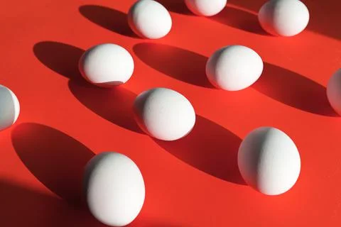Many eggs on red surface, creativity picture with white  chicken egg Stock Photos