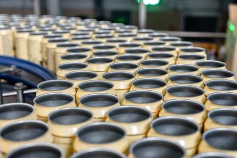 Many empty beer cans on the conveyor. Stock Photos