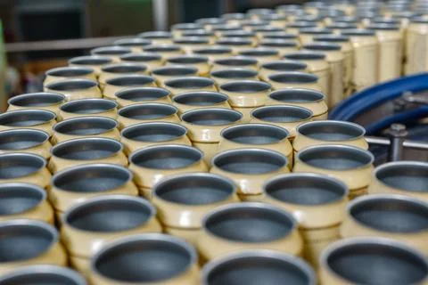Many empty beer cans on the conveyor. Stock Photos