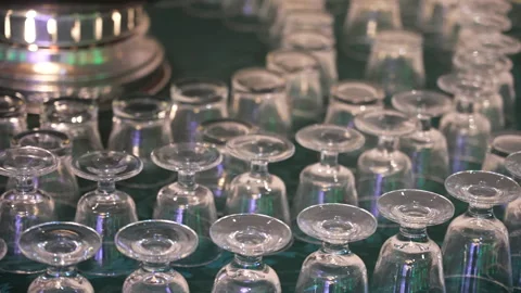 Many empty clear glass cups arranged on a green tablecloth Vídeo Stock 335270827