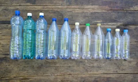 Many empty plastic bottles lie on the wooden floor. plastic pollution Stock Photos
