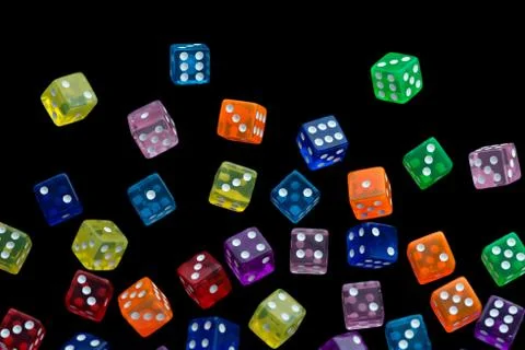 Many falling translucent  multicolored  dices with white dots on black backgr Stock Photos