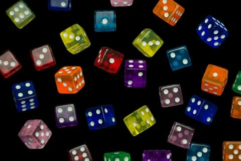Many falling translucent  multicolored  dices with white dots on black backgr Stock Photos