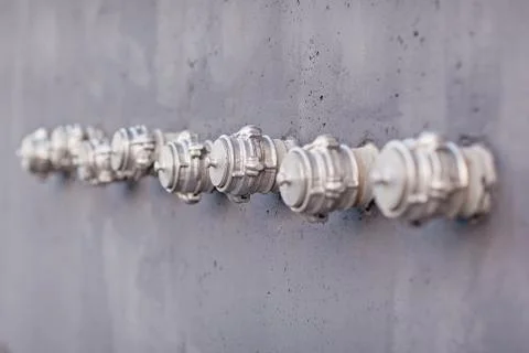 Many fire hydrants on grey wall Stock Photos