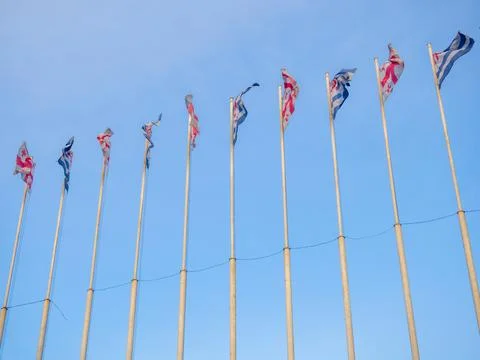 Many flags on flagpoles. Flags in the wind. State symbols Stock Photos