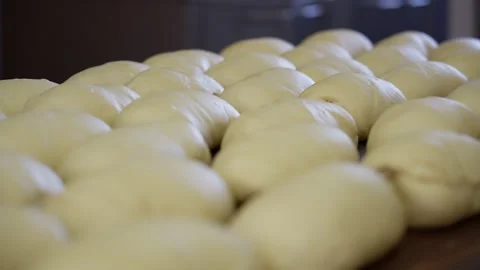 Many forms of bread from dough lie on the table. Baker and bakery fresh pastries Stock Footage 313532409