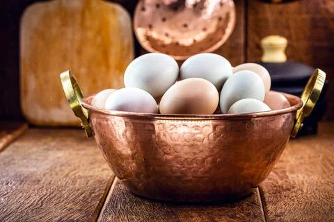 Many free-range eggs in a rustic kitchen, Brazilian eggs in a copper pot Stock Photos
