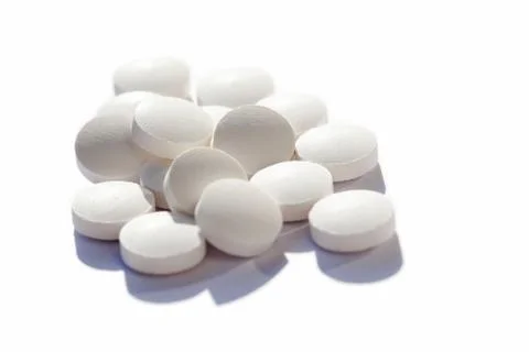 Many generic small round white pills, lots of little tablets on white Stock Photos