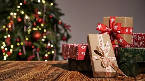 Many gift boxes wrapped in multi-colored paper on a wooden table Foto stock