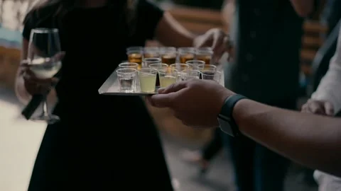 Many glasses with alcoholic drinks on the tray are served to the guests Stock Footage 236629595