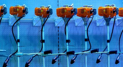 Many grass trimmer in workshop room, blurred background Stock Photos