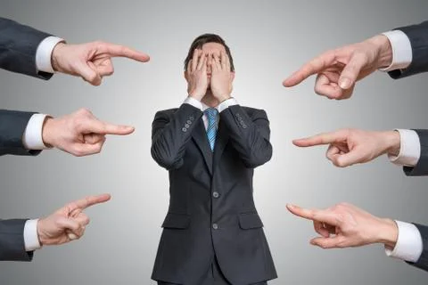 Many hands are pointing on guilty man and blame him. Stock Photos