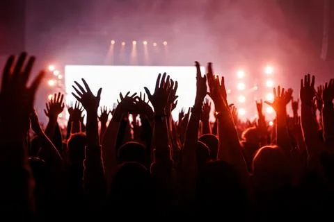 Many Hands Raised in a Crowd at a Red Lit Live Rock Concert Stock Photos