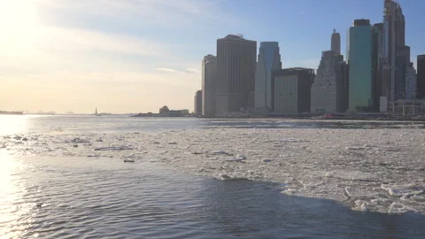 Many Ice floes flow down on the East River along Lower Manhattan skyscraper Stock Footage 336895108