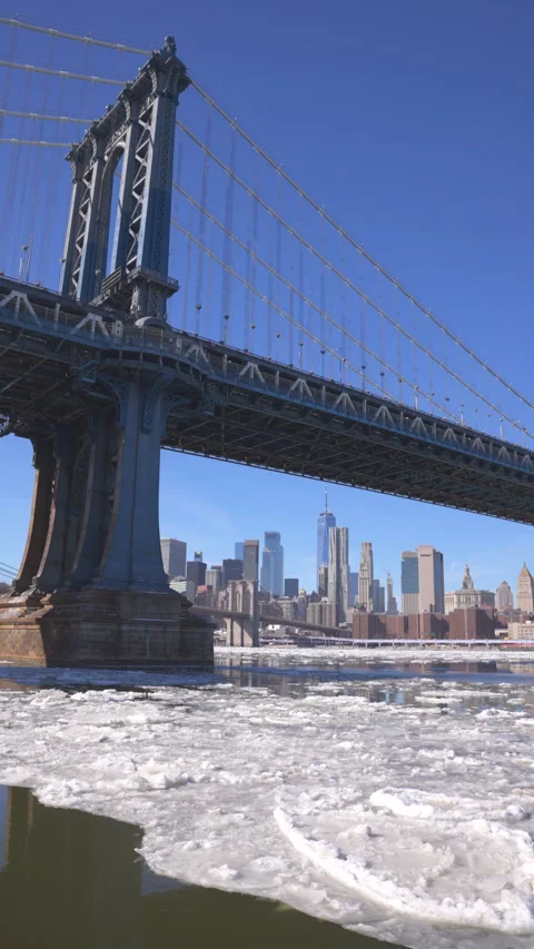 Many Ice floes flow up on the East River beneath the Manhattan Bridge. Stock Footage 336860113