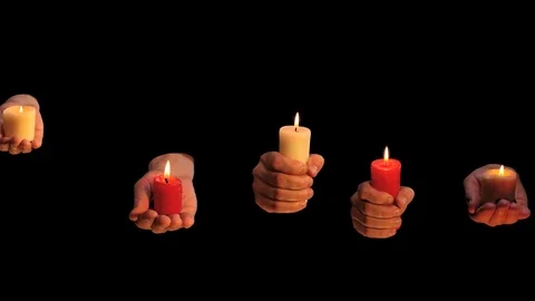Many isolated on black hands keeps burning candles Stock Footage 73249083
