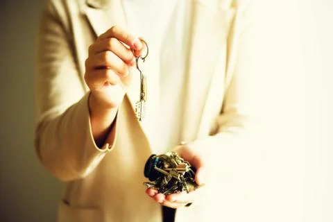 Many keys in hands on light background. Sunny morning light. Copy space Stock Photos