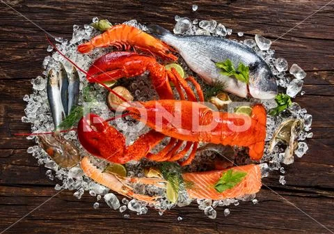 Many kind of seafood, served on crushed ice, placed on old wooden planks Stock Photos