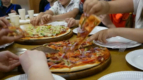 Many kinds of tasty pizzas on table. Children take pieces of pizza from plate Stock Footage 103734057