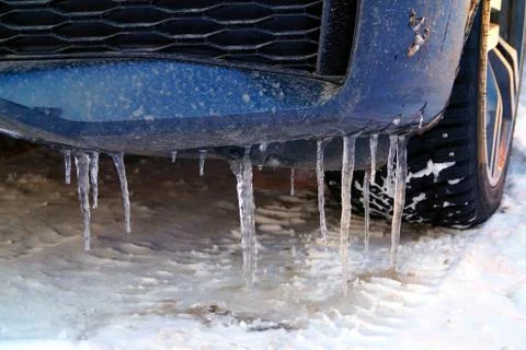 Many large and sharp icicles hang on the car. Stock Photos