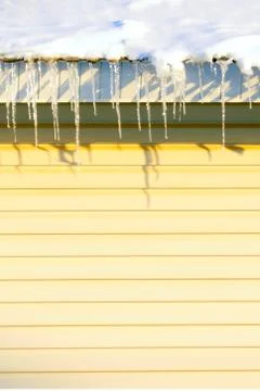 Many large and sharp icicles hang on the roof of the house. Foto stock
